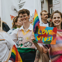 Mennesker som holder opp en plakat med teksten "Love wins"